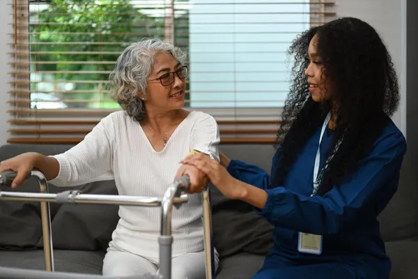 Healthcare professional providing compassionate care to an elderly patient during a home visit