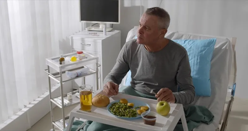 Senior patient enjoying a meal during recovery, demonstrating improved swallowing outcomes